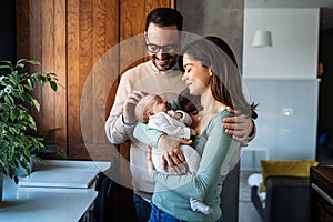 Portrait of parents and newborn baby. Father and mother kiss and hug a beautiful newborn child. .