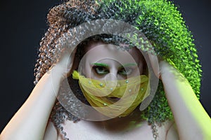 Portrait of Passionate Caucasian Girl With Frizzy Colorful Hair and Artistic Facial Mask.Posing Against Black