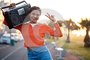 Portrait, peace sign and woman with radio in the street for skating, happiness or fashion. Smile, walking and young girl