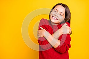 Portrait of peaceful calm kid hug embrace herself enjoy warm soft comfy sweater pullover wear red stylish lifestyle