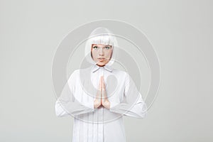 Portrait of peaceful cute young woman standing and praying