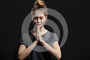 Portrait of peaceful european female holding palms in pray or namaste greeting