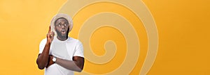 Portrait of a pensive afro american man in glasses looking up at copyspace isolated on a yellow background