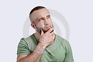 Portrait of a pensive bearded man of caucasian appearance in casual clothes.