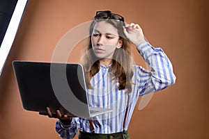 Portrait of a pensive beautiful stylish brunette young woman in glasses, standing, watching and reading the news on the