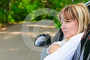 Portrait of a pensive female driver 50 years