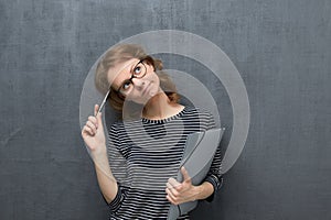 Portrait of pensive girl holding folder and pen