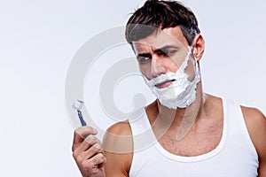 Portrait of a pensive man shaving