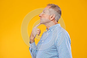 Portrait of pensive mature man looking aside at studio