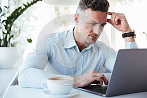 Portrait of a pensive mature man using laptop computer