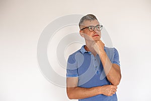 Portrait of pensive mature man wearing glasses thinking