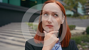 Portrait pensive thinking serious Caucasian ginger hair business woman in city outdoors businesswoman think problem