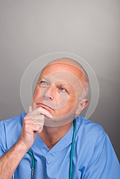 Portrait of pensive / thoughtful doctor, wearing surgical mask and stethoscope.