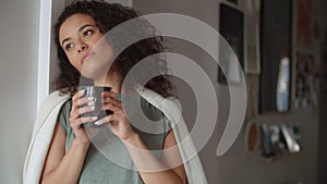 Portrait of pensive woman drinking coffee or tea at home.