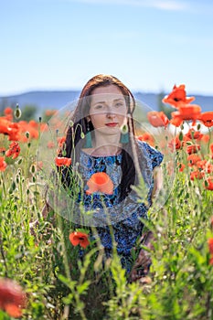 Portrait of pensive woman among poppy flowers