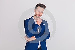 Portrait of pensive young man wearing a blue suit