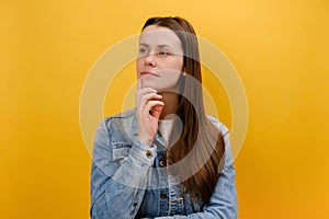 Portrait of pensive young woman holding her chin and seriously thinking over problem solution, having thoughtful expression,