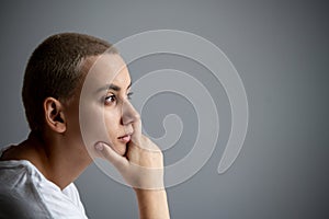 Portrait of pensive young woman with short hair on white background. Copy space