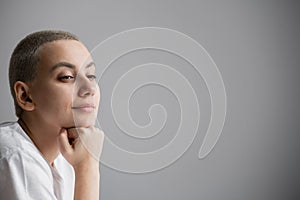 Portrait of pensive young woman with short hair on white background. Copy space