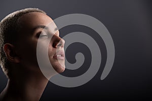 Portrait of pensive young woman with short hair on white background. Copy space