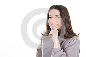 Portrait pensive young woman smiling looking aside with charming cute smile posing in white copy space wall background