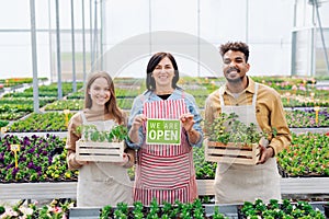 Portrait of people working in greenhouse in garden center, store open after lockdown.