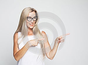 Portrait of perfect old impressed woman in white t-shirt demonstrate, looking, pointing with fingers up