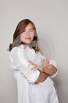 Portrait of perfect young smiling pregnant woman posing on white studio background