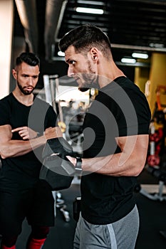 Portrait of personal trainer helping out and assisting clients in the gym. Fitness details of healthy life, dumbbell training