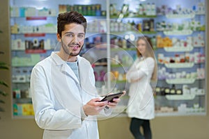 Portrait of pharmacist holding digital tablet in pharmacy