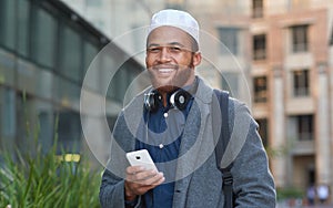 Portrait, phone and muslim with an man in the city on his morning commute listening to music during the day. Mobile