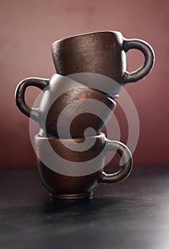 portrait photo of antique cups made of clay in a stacked position and using lighting