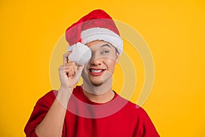 Portrait photo of handsome Asian man wearing christmas cap keeping holding white soft cotton ball in hand looking at side