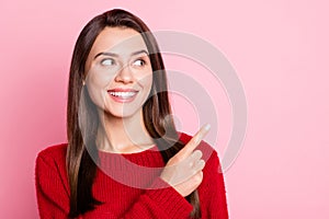 Portrait photo of happy smiling young woman with straight brunette hair looking at side pointing on blank space isolated