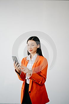 Portrait photo of young beautiful Asian woman feeling happy and holding smart phone, tablet and laptop with black empty screen on