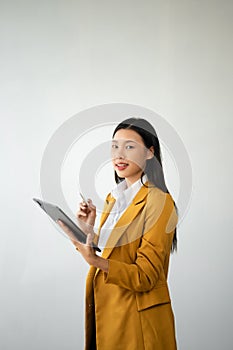 Portrait photo of young beautiful Asian woman feeling happy and holding smart phone, tablet and laptop with black empty screen on