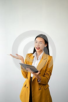 Portrait photo of young beautiful Asian woman feeling happy and holding smart phone, tablet and laptop with black empty screen on