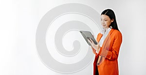 Portrait photo of young beautiful Asian woman feeling happy and holding smart phone, tablet and laptop with black empty screen on