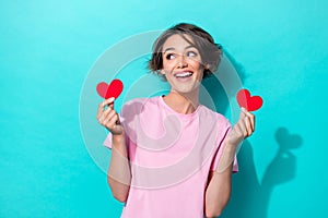 Portrait photo of young cute funny smiling woman hold paper red symbol heart love look interested empty space isolated