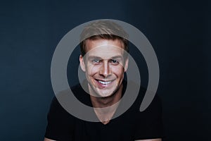 Portrait photo of young happy man with a blinding smile in v nec