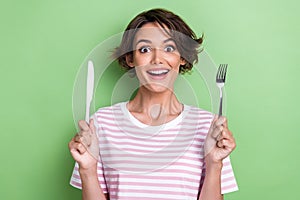 Portrait photo of young smiling happy positive angry woman hold knife fork smiling excited want eat some food isolated