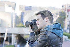 Portrait of photographer with camera in action in the street.