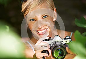 Portrait, photographer and camera lens with woman in forest for trees, environment and relax. Shooting, nature and