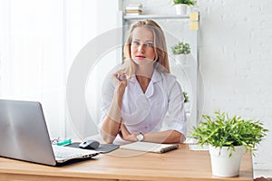 Portrait of physician working in her office sitting workplace.