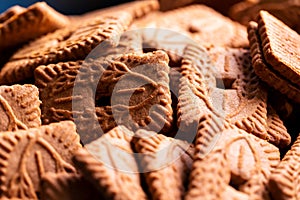 A portrait of a pile of brown cookies called speculoos or speculaas in Belgium or the Netherlands. The spiced biscuit is very