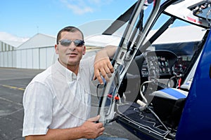 portrait pilot standing in front helicopter