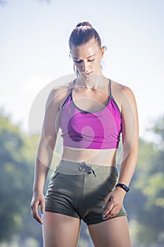 A beautiful woman is resting, after doing fitness exercises in a beautiful park.