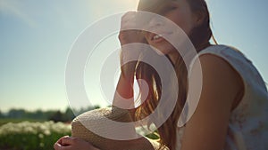 Portrait of playful girl smiling in sun reflection. Young woman playing hair.