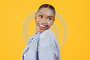 Portrait of playful pretty black woman smiling looking aside, studio