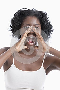 Portrait of a playful young woman shouting over white background